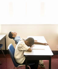 Two young students asleep at a desk in the classroom. Photograph: Blend Images/Photoshot